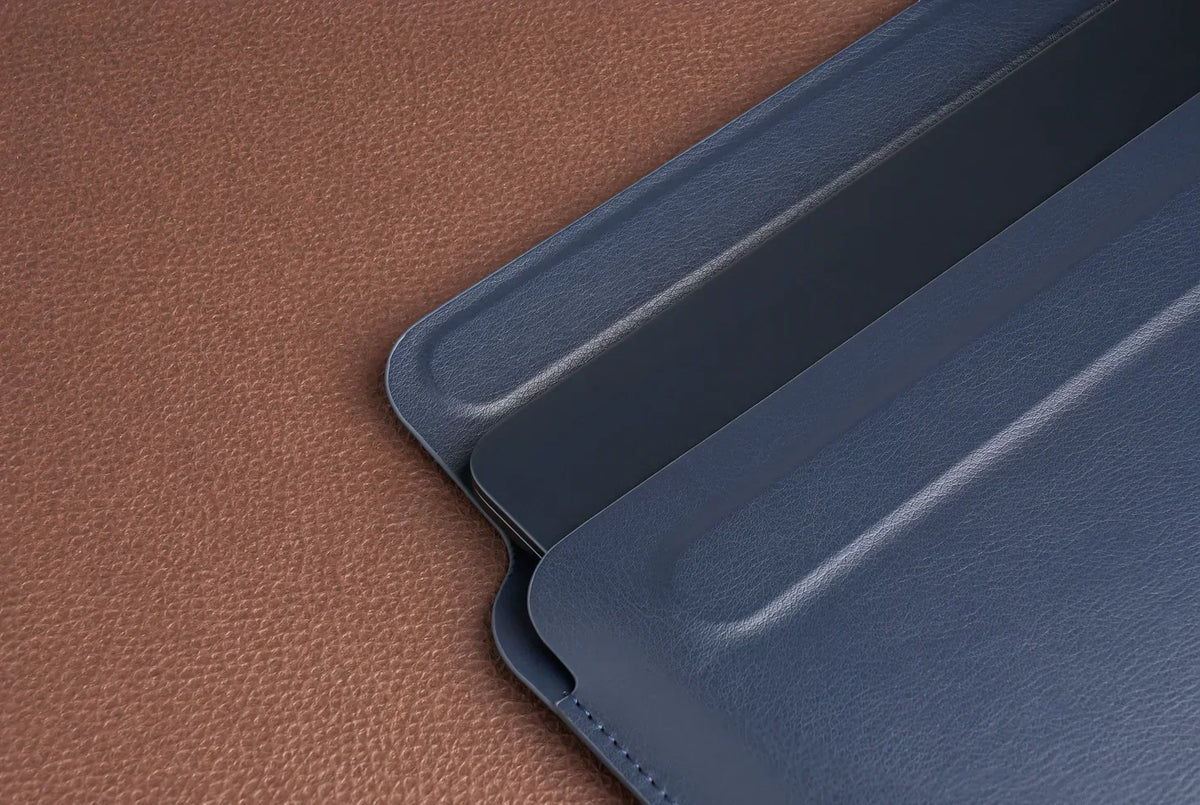 Navy Tekne blue leather-look tablet case with stitched edges on brown textured surface