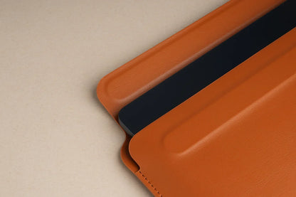 Brown Tekne leather folio case with dark tablet partially inserted, stitched edges on beige background
